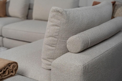 Beige bank met verschillende elementen en een sfeervolle rood / roze interieurstyling.