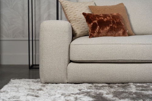 Beige bank met verschillende elementen en een sfeervolle rood / roze interieurstyling.