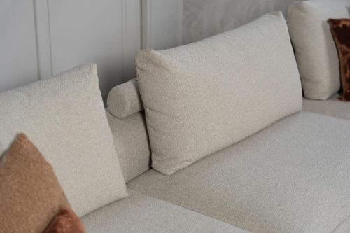 Beige bank met verschillende elementen en een sfeervolle rood / roze interieurstyling.