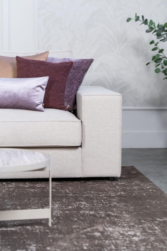 Beige hoekbank met grote hoek, gestyled met woonaccessoires in Burgundy.