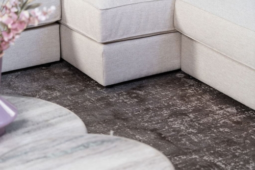 Beige hoekbank met grote hoek, gestyled met woonaccessoires in Burgundy.