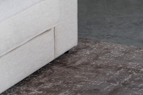Beige hoekbank met grote hoek, gestyled met woonaccessoires in Burgundy.