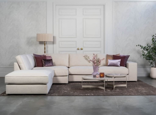 Beige hoekbank met grote hoek, gestyled met woonaccessoires in Burgundy.