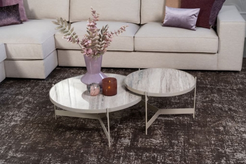 Beige hoekbank met grote hoek, gestyled met woonaccessoires in Burgundy.