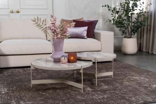 Beige hoekbank met grote hoek, gestyled met woonaccessoires in Burgundy.