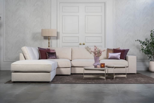 Beige hoekbank met grote hoek, gestyled met woonaccessoires in Burgundy.